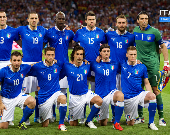 Soccer players in Italy's blue jerseys lined up on the stadium pitch before the match; goalkeeper in green.
