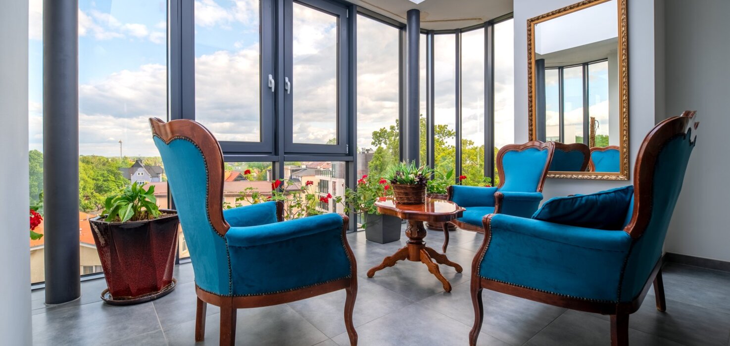 Strefa relaksu w hotelu z eleganckimi fotelami i widokiem na otoczenie nadmorskie