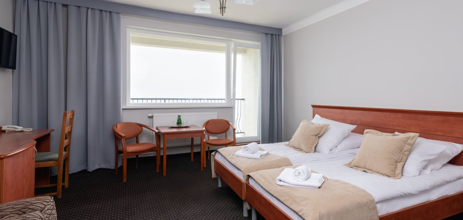 Przestronny pokój hotelowy z balkonem i wygodnym łóżkiem