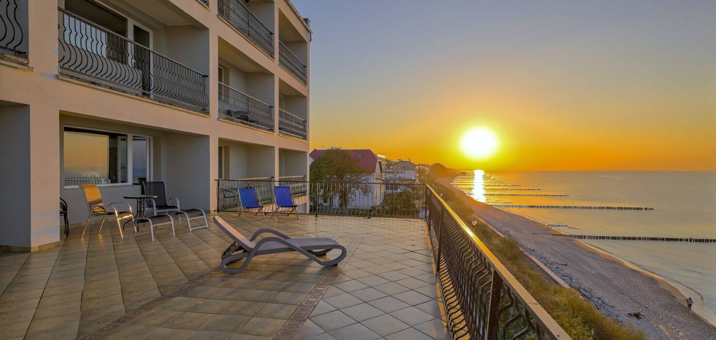Taras hotelowy z widokiem na zachód słońca nad morzem