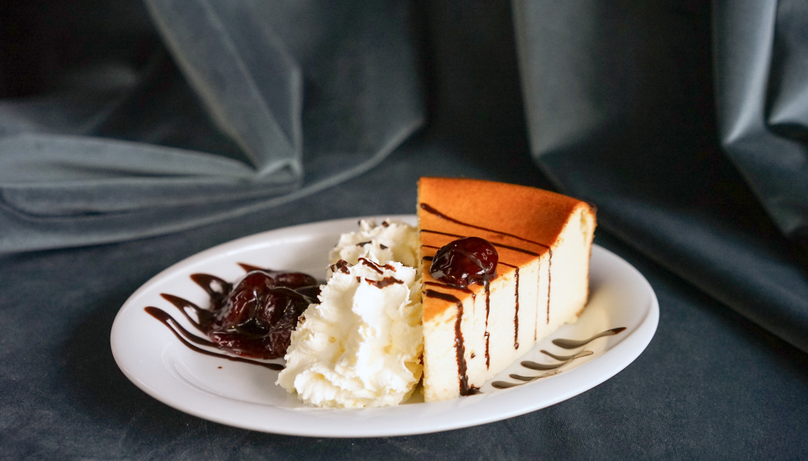 sernik na zimno z bitą śmietaną z dekoracjami z wiśni w syropie kawiarni w hotelu Irys w Świnoujściu