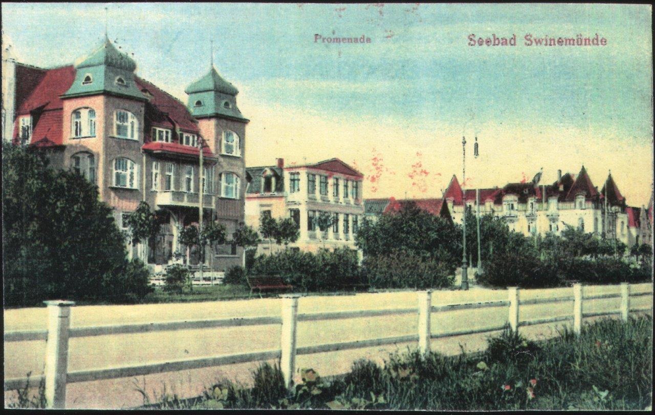 Promenada nadmorska z historycznymi, dużymi budynkami w stylu secesyjnym otoczonymi zielenią i niskim ogrodzeniem