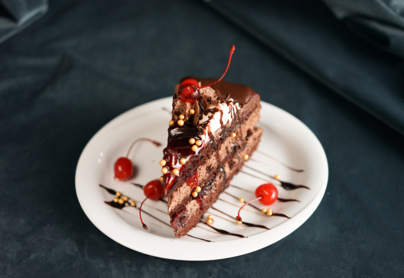 porcja tortu czekoladowego z dekoracjami z wisienek w kawiarni w hotelu Irys w Świnoujściu