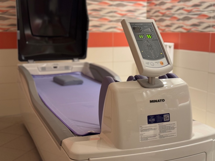 Nowoczesna kapsuła do hydroterapii z regulowanym panelem sterowania, w spa hotelowym z kolorową mozaiką ścienną.