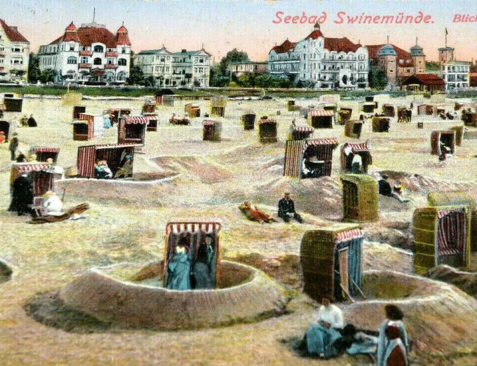 Plaża w Swinemünde z licznymi tradycyjnymi koszami plażowymi i historycznymi budynkami w tle