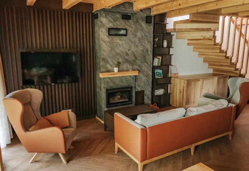 Stylowy salon z kominkiem i telewizorem na ścianie – Jabłonki Resort & SPA