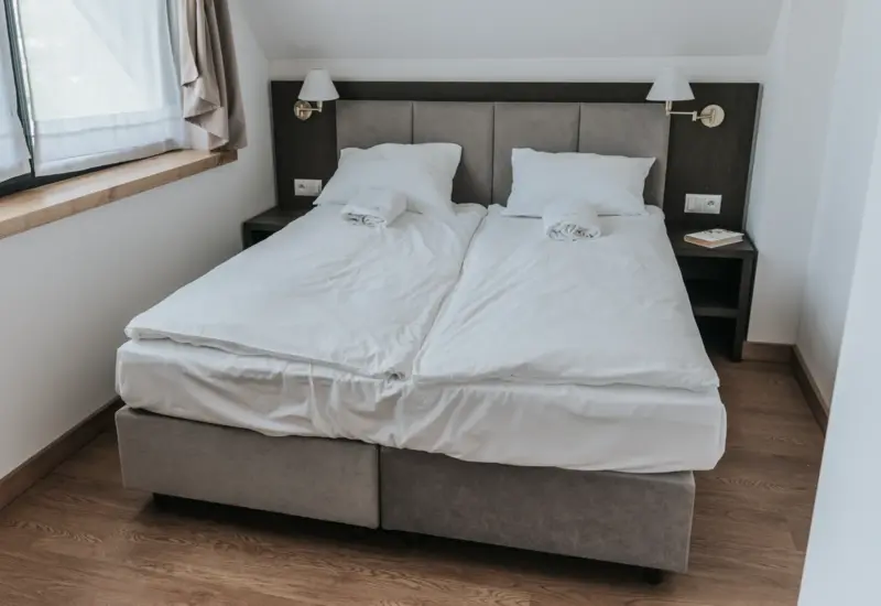 Przytulna sypialnia z podwójnym łóżkiem i lampkami nocnymi – Jabłonki Resort & SPA