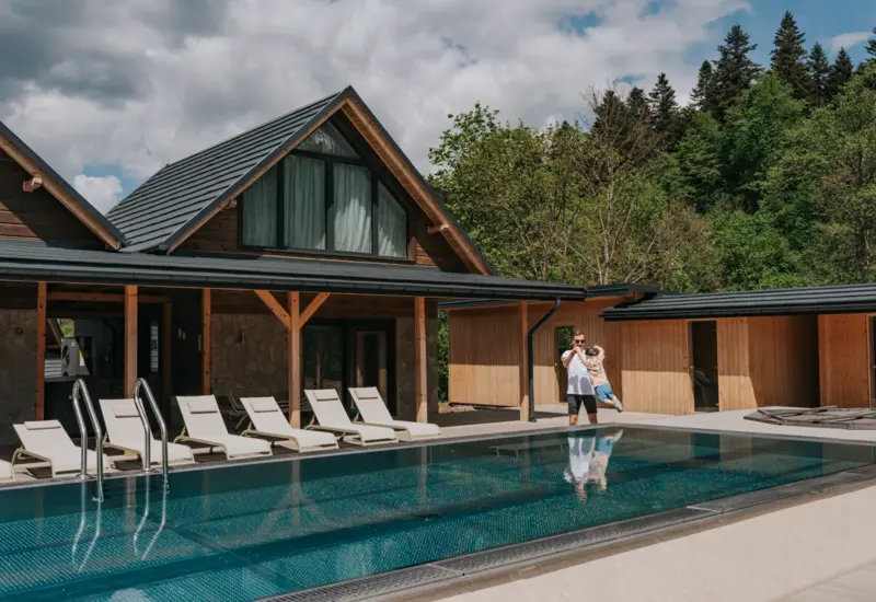 Tata podnoszący syna w górę nad wodą – Jabłonki Resort & SPA