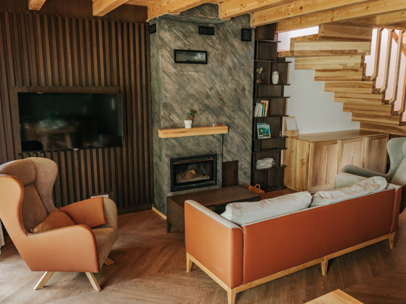 Stylowy salon z kominkiem i telewizorem na ścianie – Jabłonki Resort & SPA