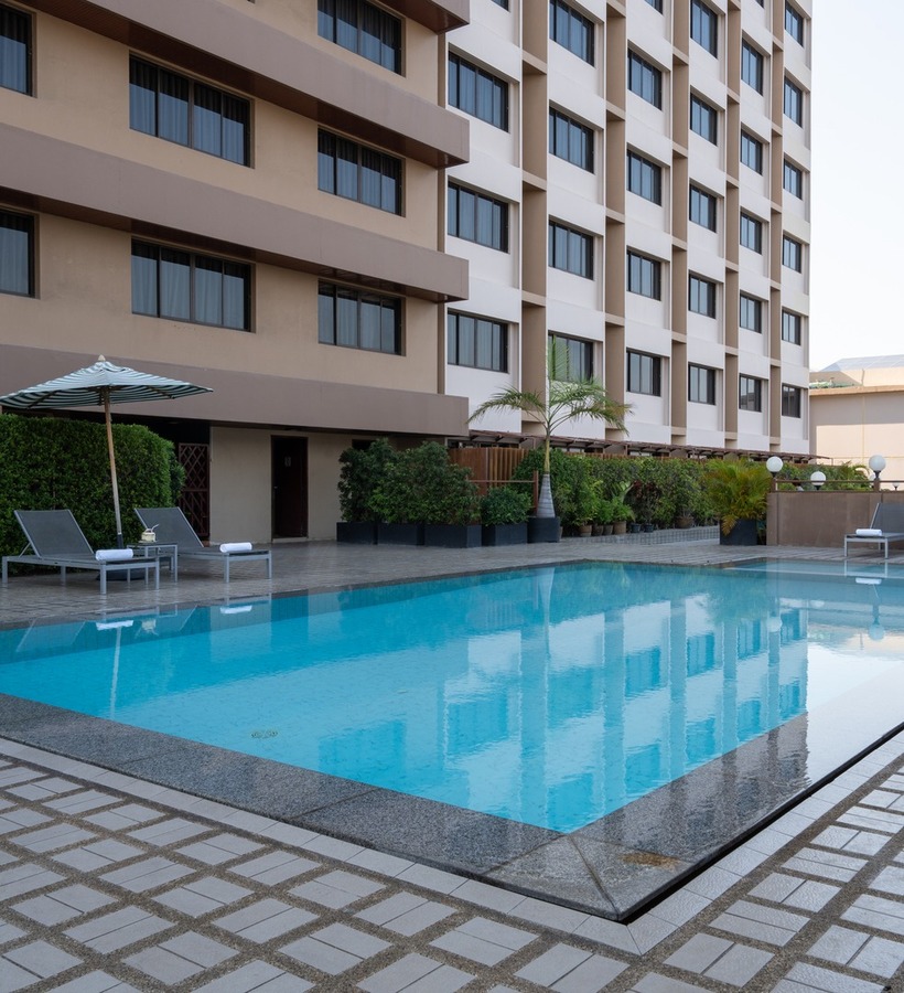 family enjoying rooftop pool at Jazzotel Bangkok skyline view