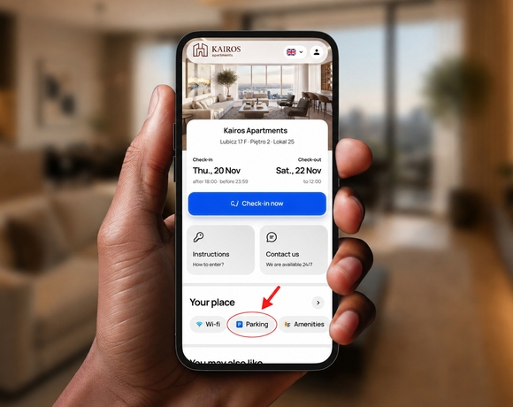 Hand holding phone showing Kairos Apartments booking screen with living-room view, check-in button and highlighted Parking amenity.