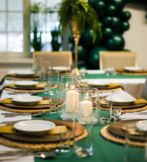 Stół z zielonym obrusem zastawiony na obiad weselny
