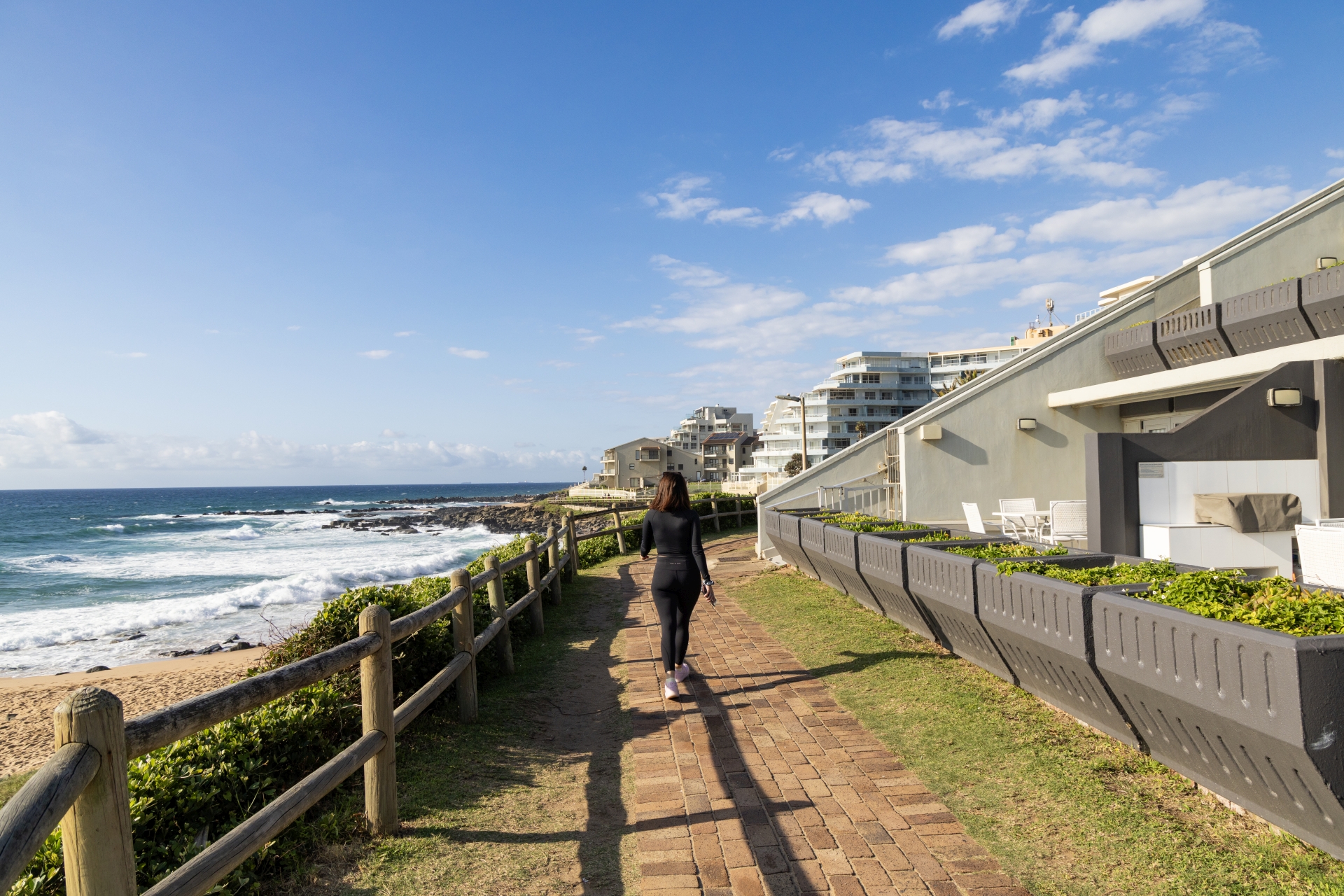 Family walking along Ballito beach near lifeguard-supervised swimming area