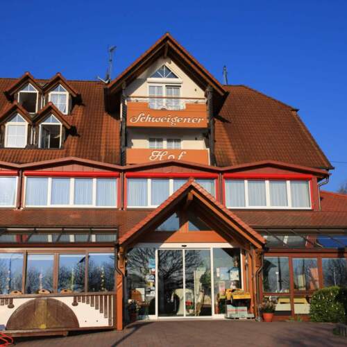 Hotel Schweigener Hof mit markanter Fassade und rotem Eingangsbereich