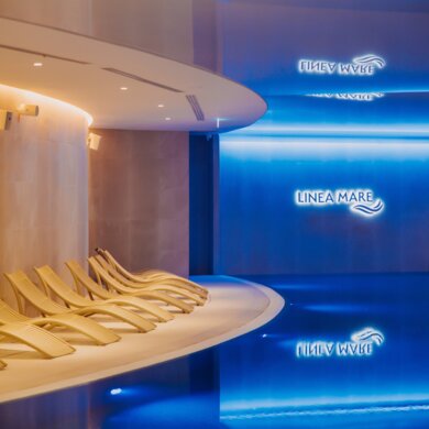 A wellness area with sun loungers at Aqua Mare and an indoor pool in the shape of a sea wave - Linea