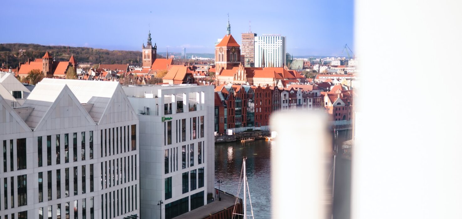 Widok z wysokiego budynku na Stare Miasto w Gdańsku oraz na fragment rzeki Motława.