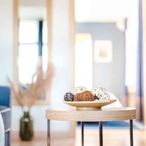 Wiklinowe ozdoby w kształcie kul, leżące na talerzu na okrągłym stoliku kawowym.