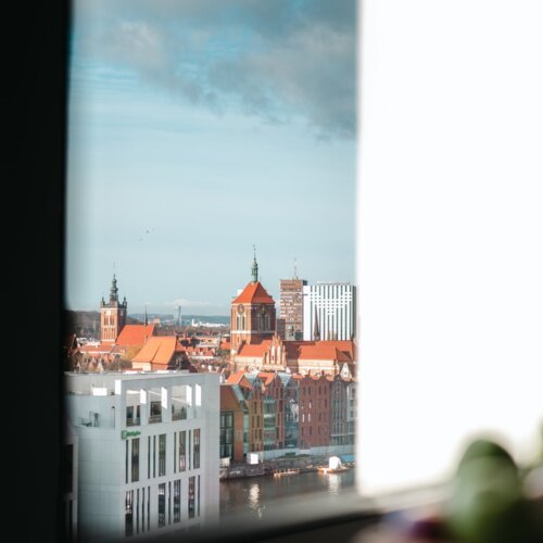 Widok z okna wysokiego budynku na Stare Miasto w Gdańsku oraz na fragment rzeki Motława.