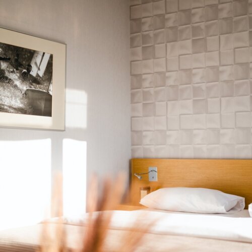 Komfortowe łóżko i czarno-biały obraz w pokoju hotelowym w Gdańsku.