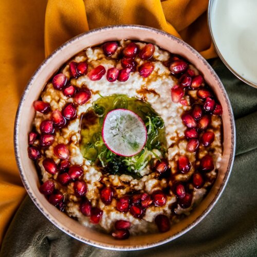 Eine Schüssel gefüllt mit Baba Ghanoush-Gericht, bestreut mit Granatapfelfrüchten.
