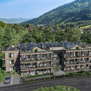 Modernes Hotel mit Panoramablick auf bewaldete Berge und grünes Tal, elegante Apartment-Balkone.