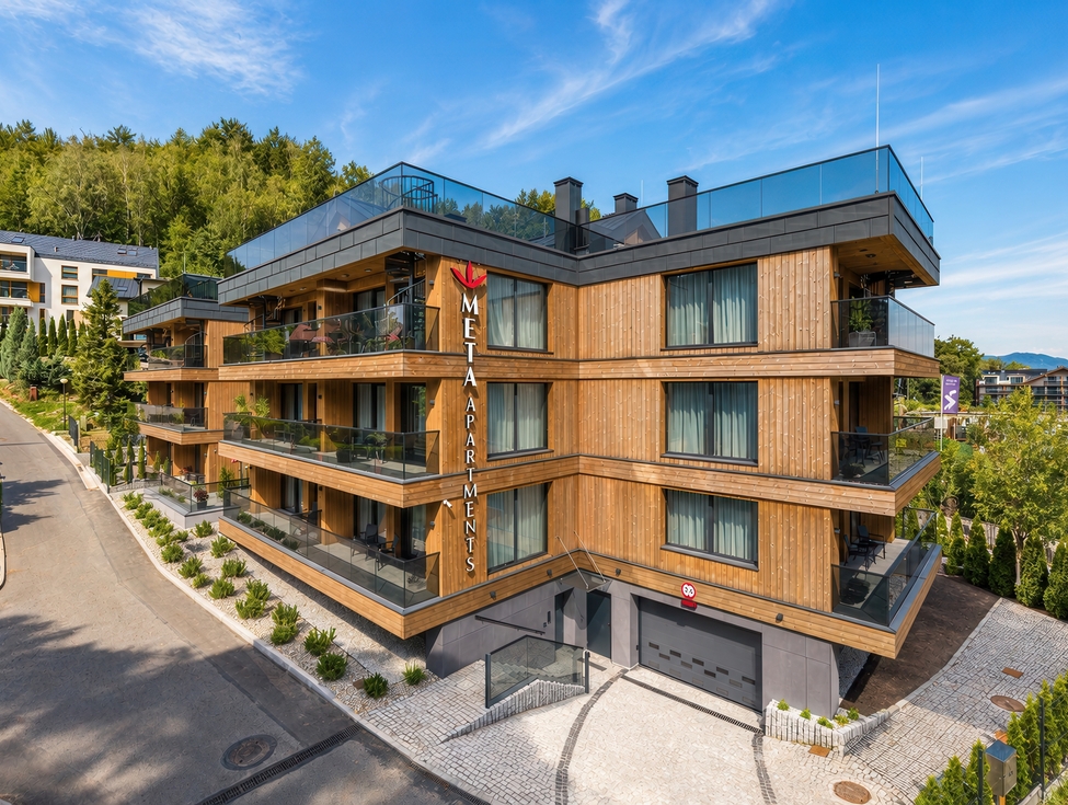 Nowoczesny drewniany hotel apartamentowy z przeszklonymi balkonami, tarasem na dachu, prywatnym parkingiem i widokiem na las