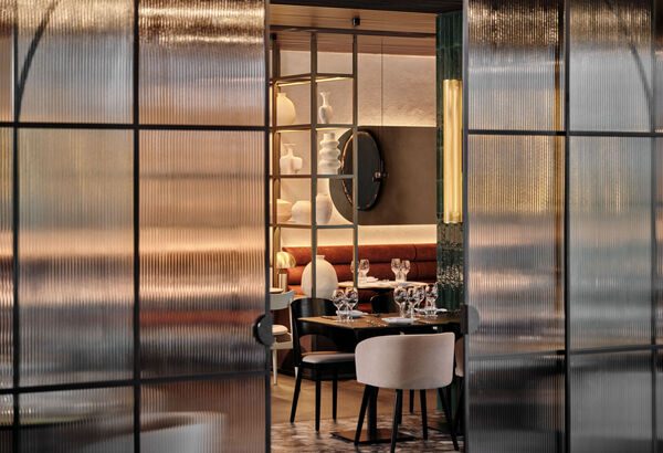 Moderní hotelová restaurace s elegantním prostřením, jemným osvětlením a dekorativními keramickými vázami