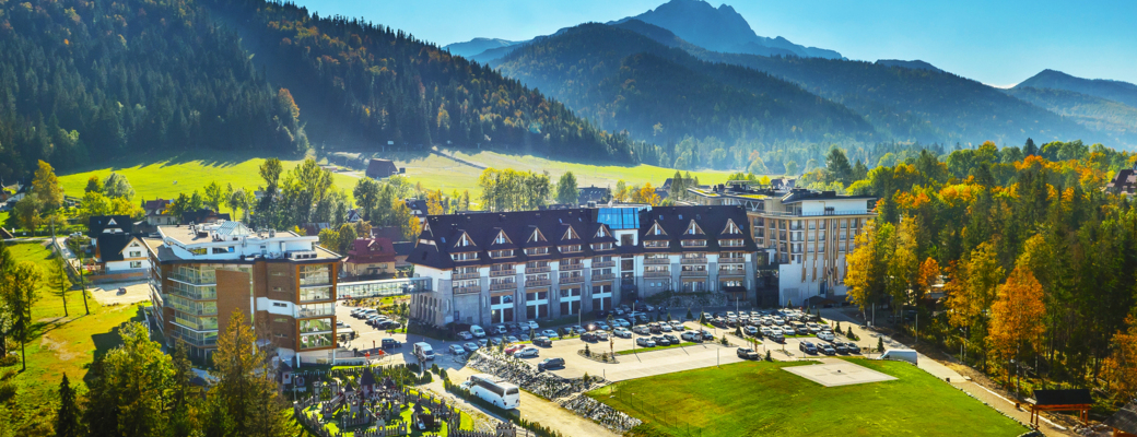 Kompleks hotelowy Nosalowy Dwór otoczony zielenią z widokiem na góry w Zakopanem