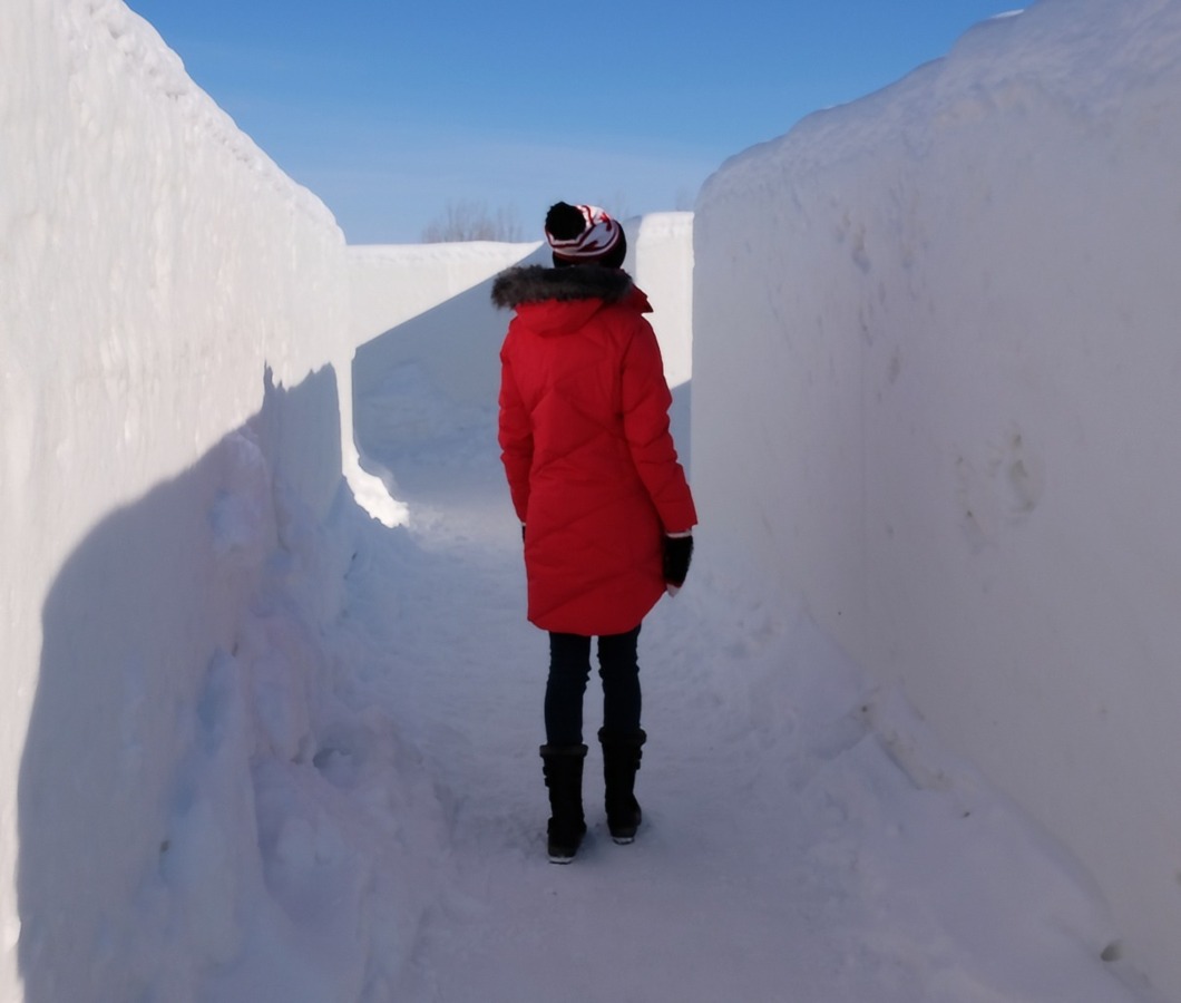 Pani spacerująca w labiryncie ze śniegu – zimowa przygoda na świeżym powietrzu