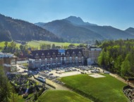 The Nosalowy Dwór hotel complex surrounded by greenery with a view of the mountains in Zakopane