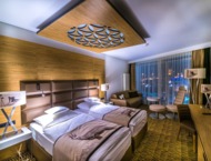 A cosy hotel room with elements of highlander architecture, two beds and a picturesque view