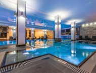Spacious, modern indoor pool with varying depths and a comfortable relaxation area
