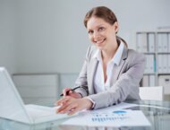 Uśmiechnięta kobieta pracująca przy laptopie