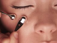 Zamknięte oko w zbliżeniu i masażer – ujęcie sugerujące zabieg kosmetologiczny