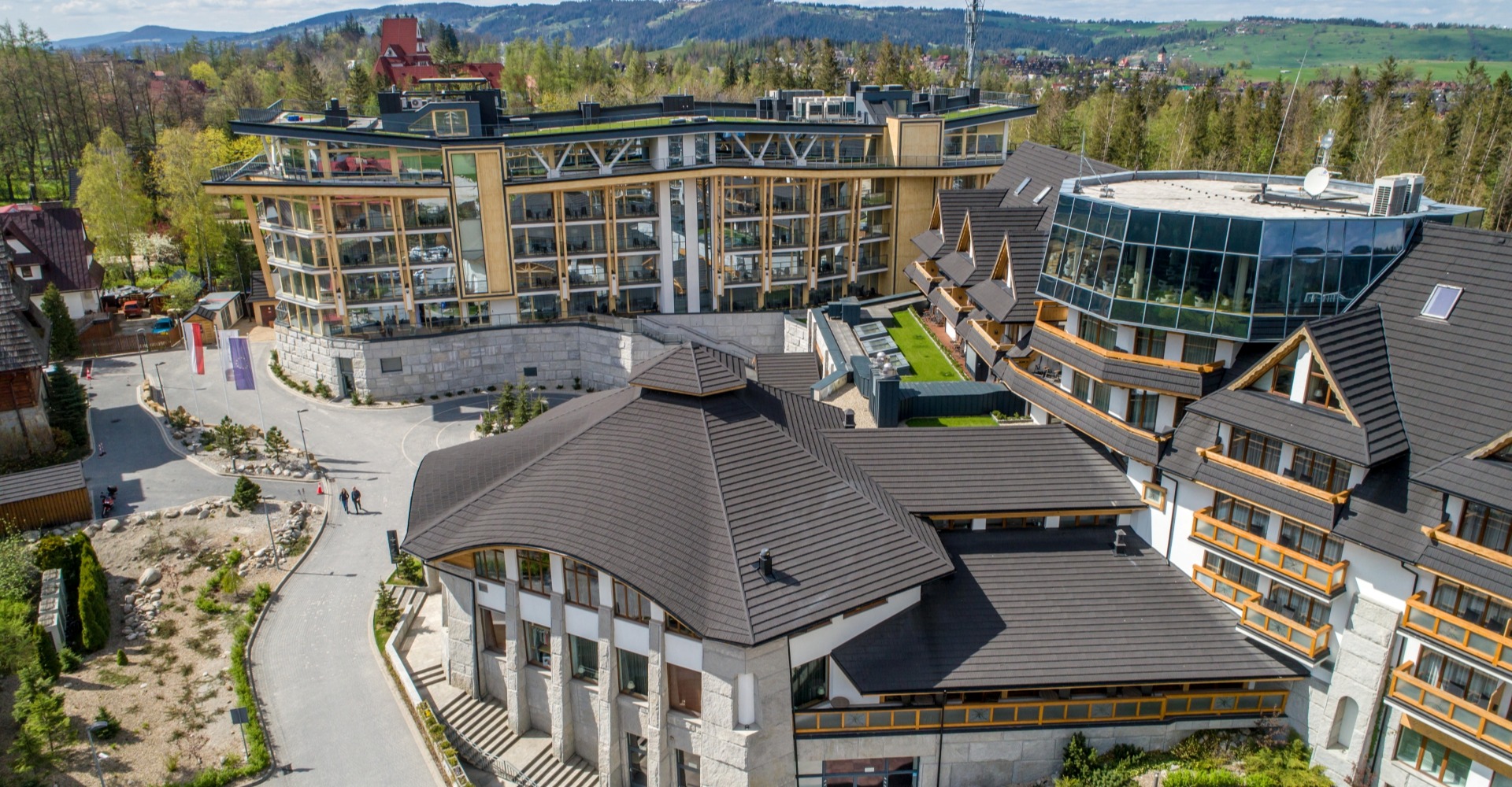 Widok z lotu ptaka na nowoczesny górski kompleks hotelowy z panoramą Tatr w tle