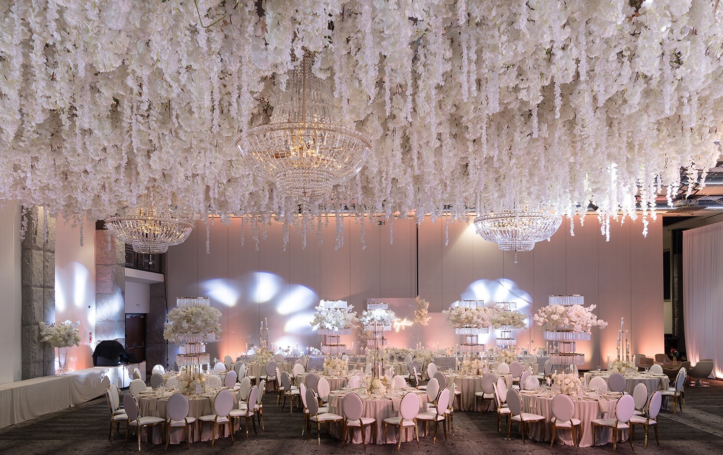 Nowocześnie i glamour przystrojona sala z kwiatowymi dekoracjami pod sufitem, gotowa na uroczystość