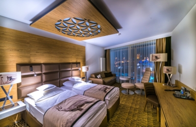 A cosy hotel room with elements of highlander architecture, two beds and a picturesque view