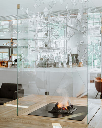 Nowoczesny kominek za przeszkleniem w hotelowym lobby