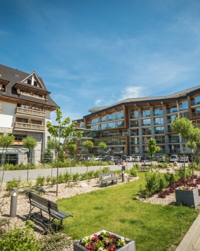 Widok na hotel w górskim stylu z ogrodu przed obiektem