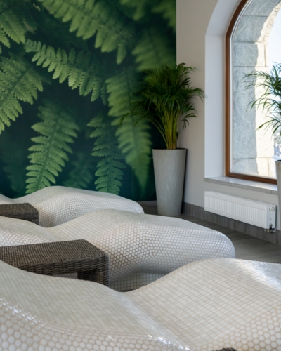Wyprofilowane leżaki w strefie wellness w przyjaznym, relaksacyjnym wnętrzu hotelu
