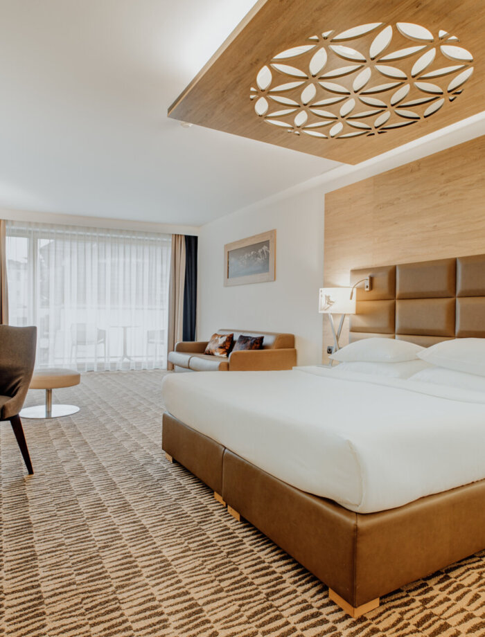 Przestronny pokój hotelowy w stylu zakopiańskim z dużym łóżkiem i widokiem przez panoramiczne okna