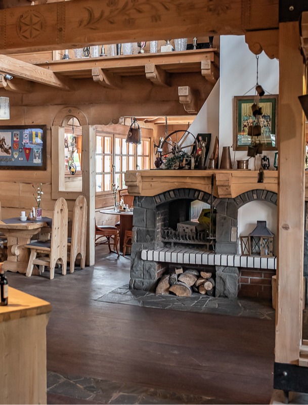 Klimatyczna restauracja w stylu zakopiańskim z góralskim kominkiem i stołami gotowymi na gości
