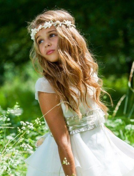 Dziewczynka w białym stroju i wianku w otoczeniu natury