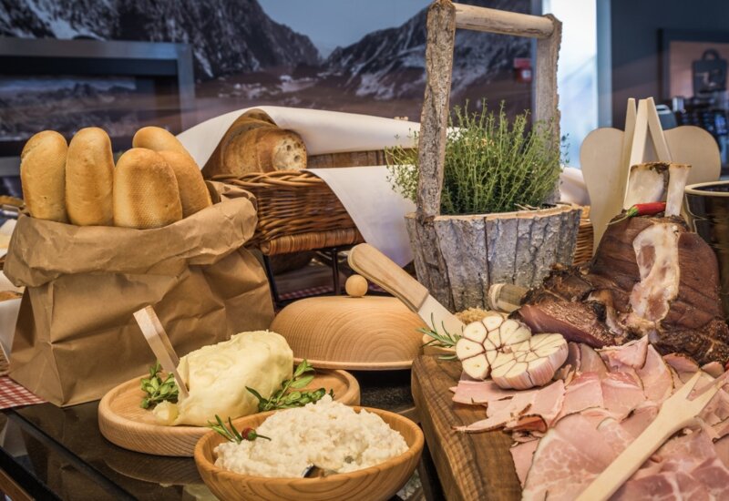 Vidiecky stôl prestretý miestnymi surovinami, občerstvením a čerstvým pečivom