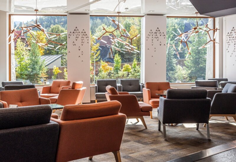 Útulná vstupná hala s modernými pohodlnými kreslami a panoramatickým výhľadom z okien