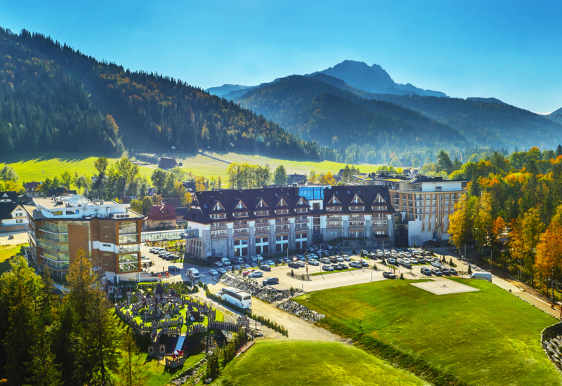 Hotelový komplex Nosalowy Dwór obklopený zeleňou s výhľadom na hory v Zakopanom