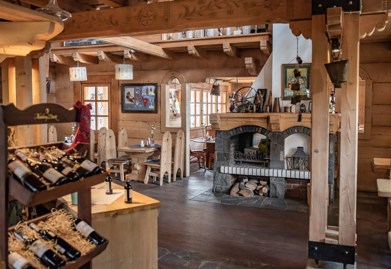 Atmosférická reštaurácia v štýle Zakopia s horským krbom a stolmi pripravenými pre hostí