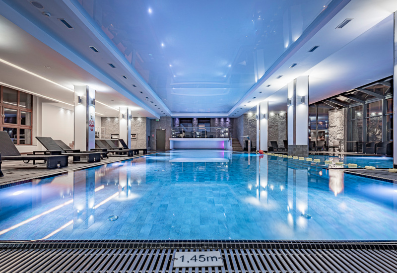 Priestranný hotelový bazén s pohodlnou oddychovou zónou vybavenou ležadlami
