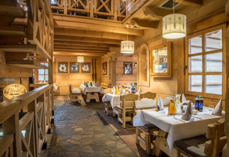 Tradičná horská reštaurácia s prestretými stolmi, pripravená na prijatie hostí