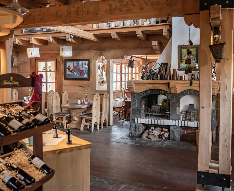 An atmospheric restaurant in Zakopane style with a highlander fireplace and tables ready for guests